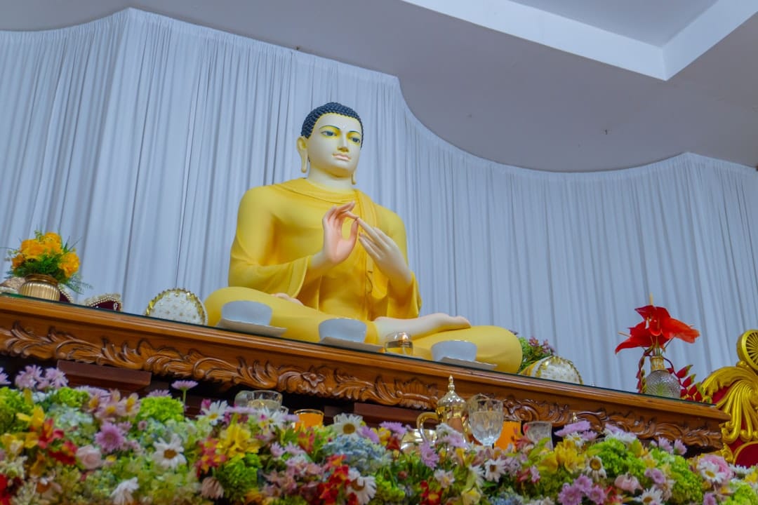 eine Buddha-Statue, die auf einem Holztisch sitzt