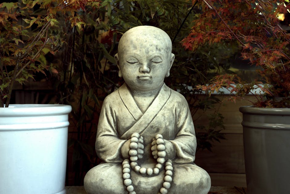 Zen-Buddhist-Statue in ruhiger Garten mit Herbstblättern.