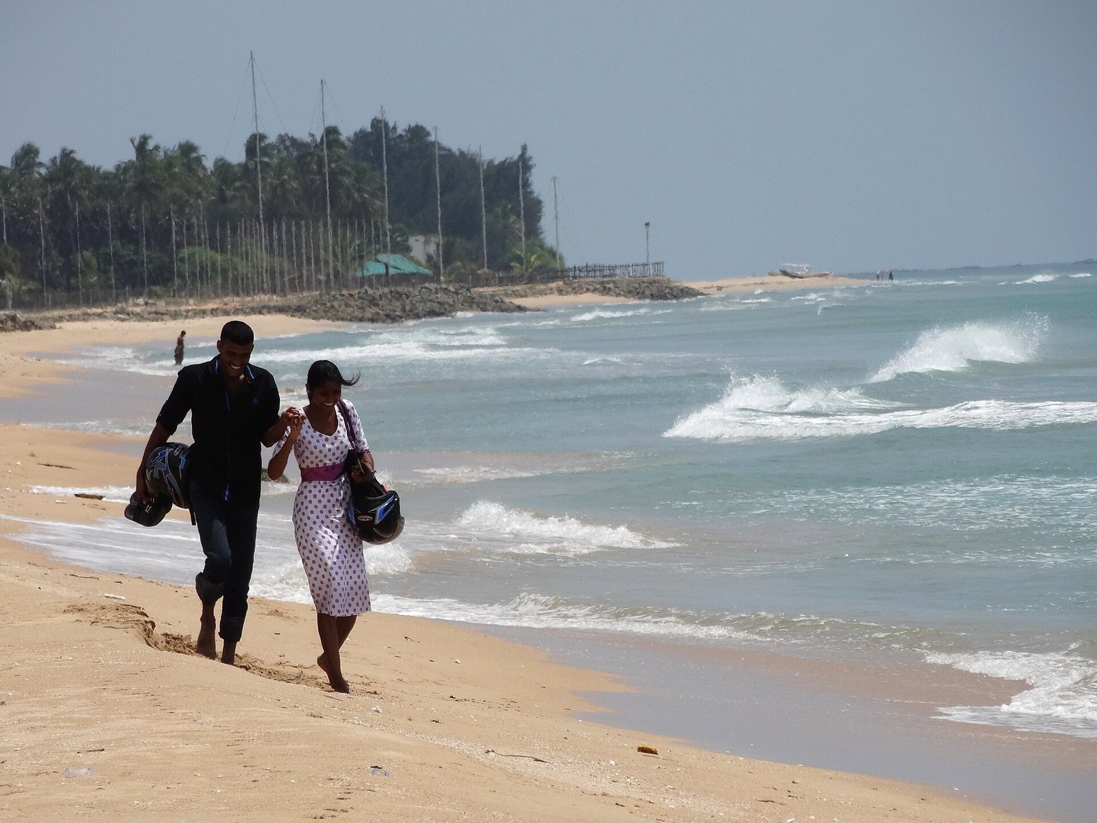 Couple walking along the shore at Nilaveli beach near Trincomalee