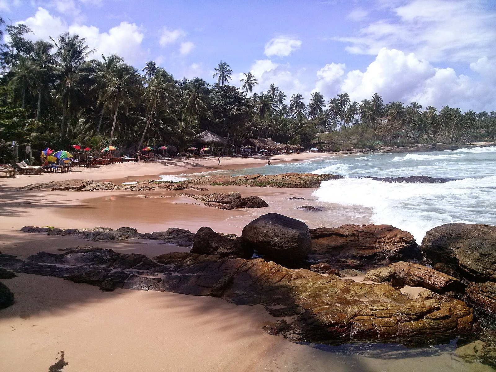 Rocky cove and palm trees at Goyambokka beach near Tangalle