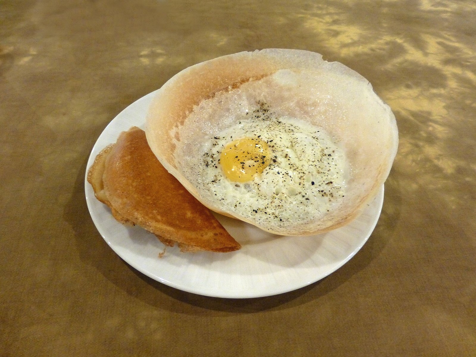 Egg hopper with a runny yolk served on a plate