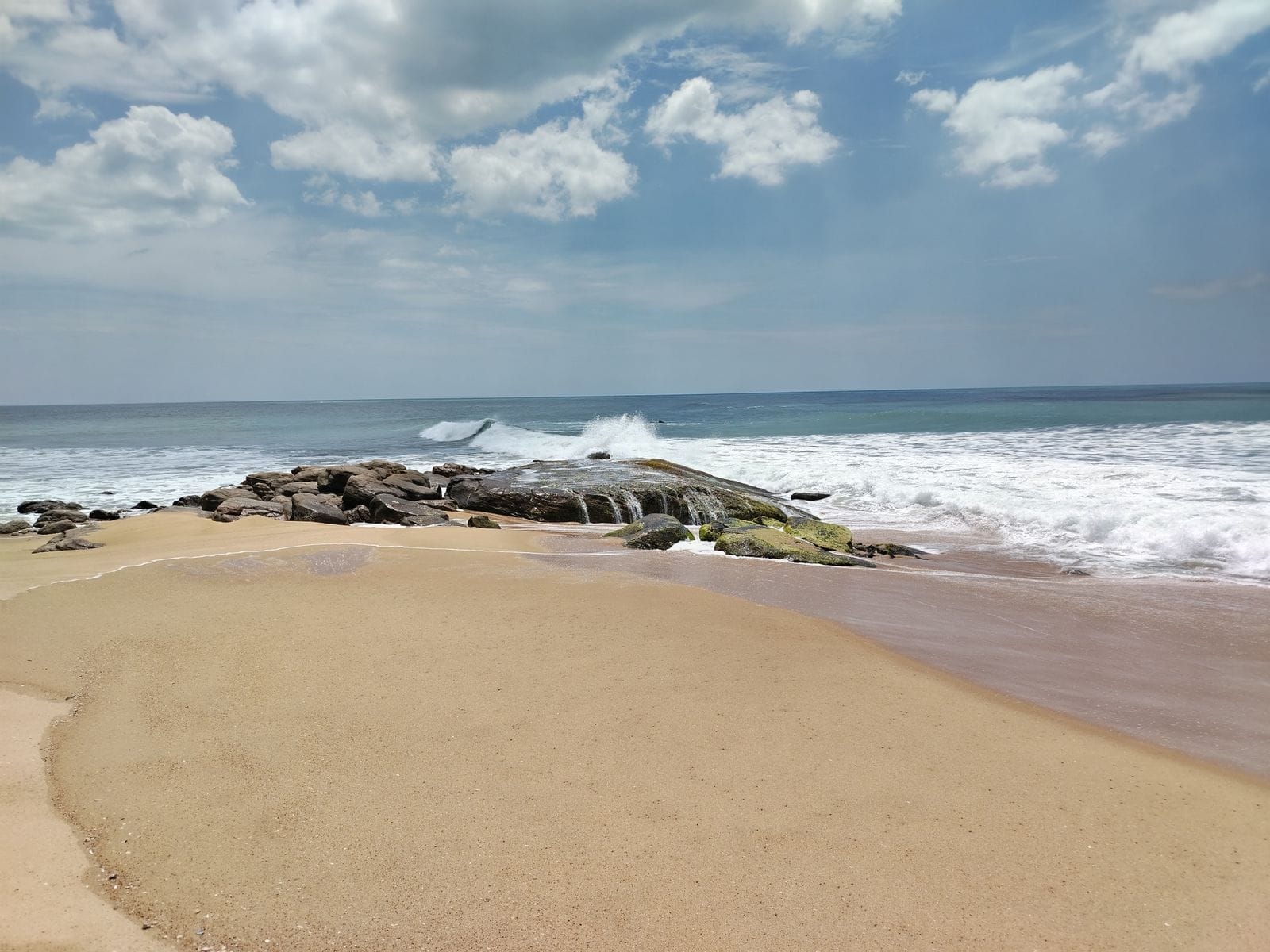 Calm waves on Pottuvil beach with clear skies