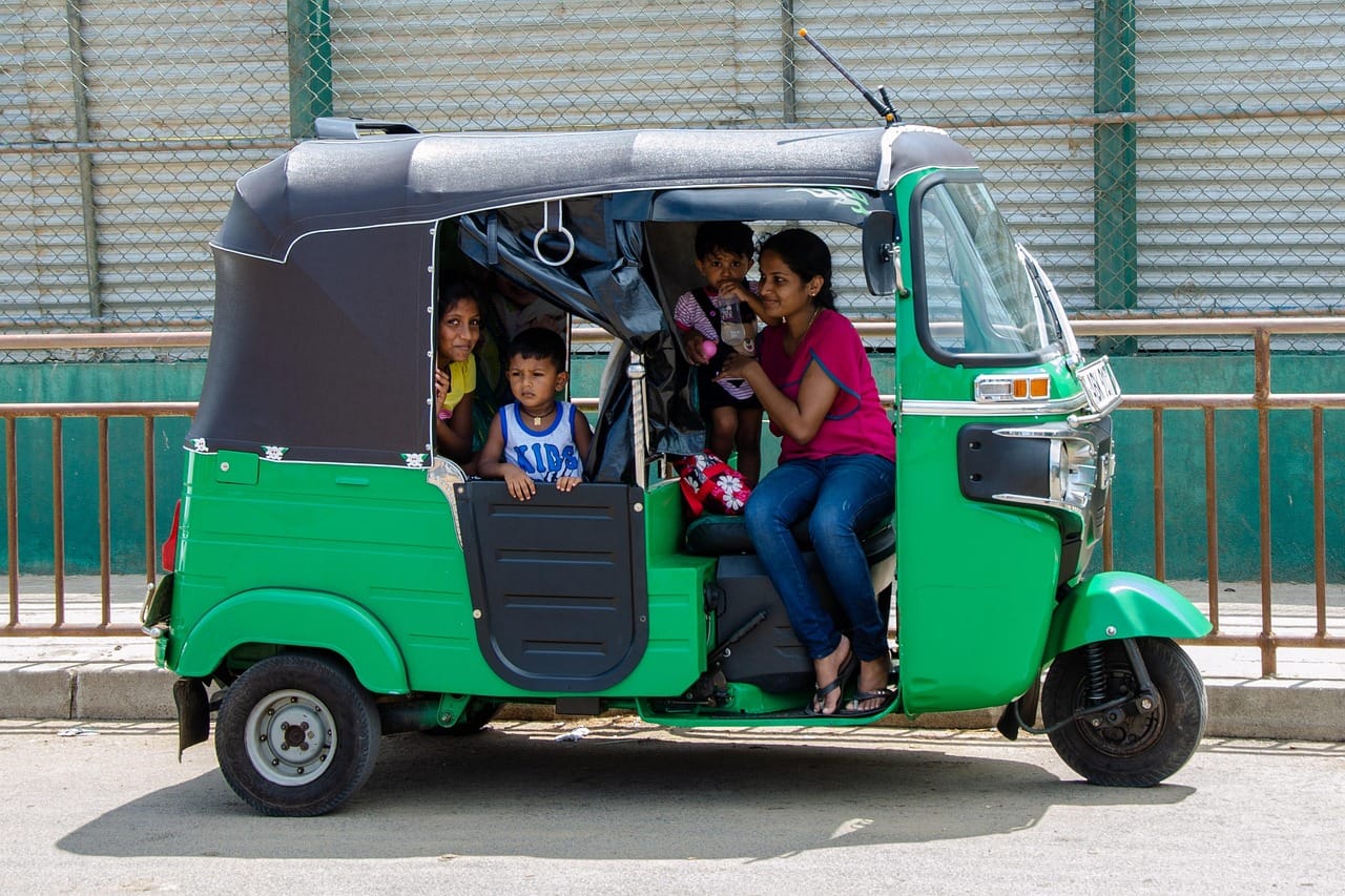 Family riding in a green tuk-tuk in Sri Lanka