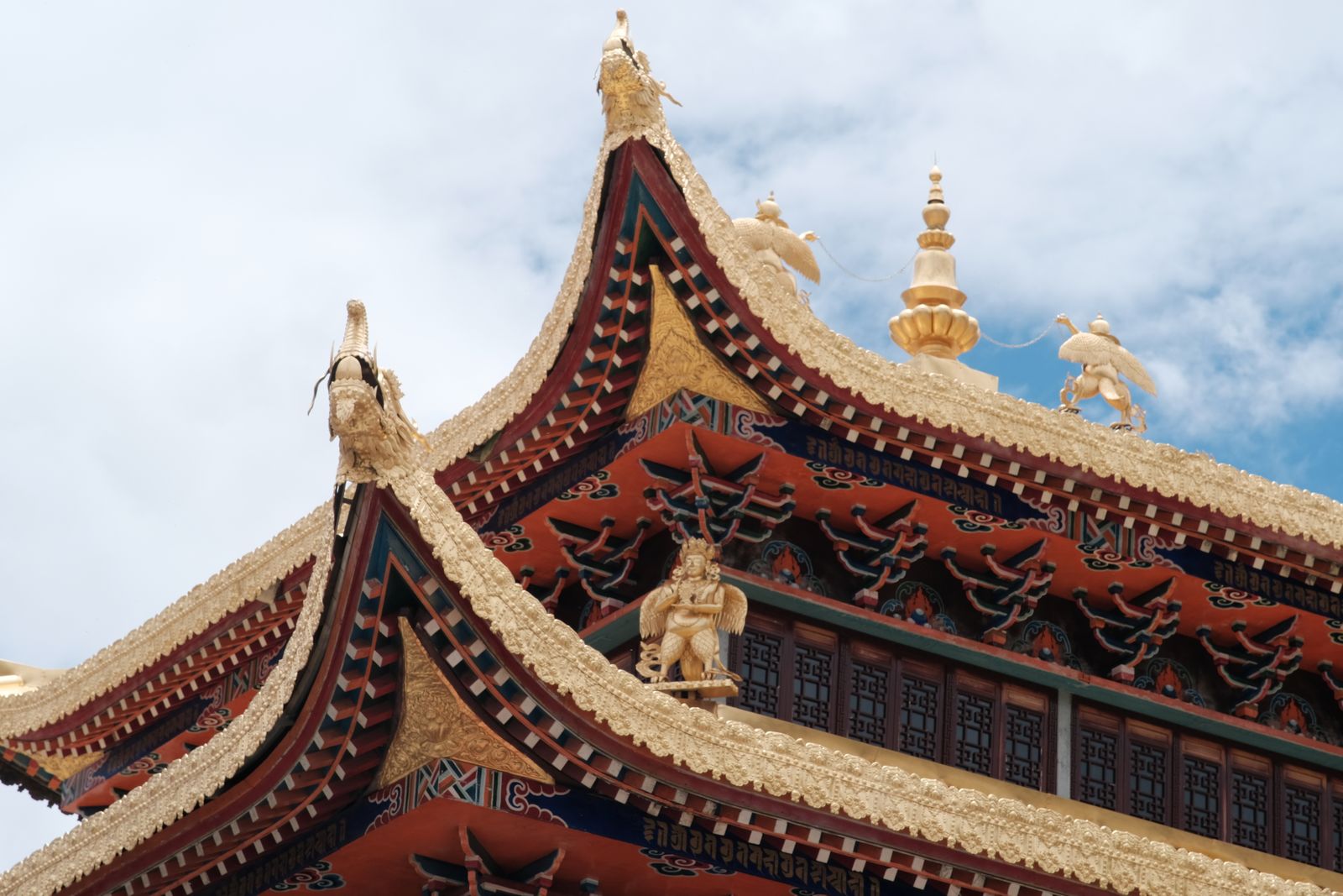 Nahaufnahme eines traditionellen Tempeldachs mit aufwendigen Details vor blauem Himmel.