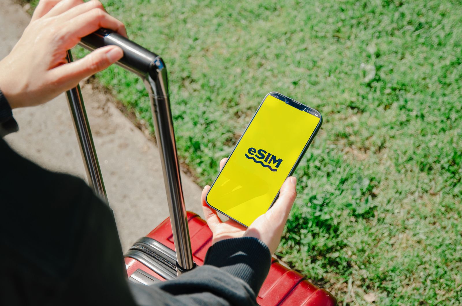 Ein Reisender mit Gepäck aktiviert eine eSIM auf seinem Handy Ein Reisender mit Gepäck aktiviert eine eSIM auf seinem Handy