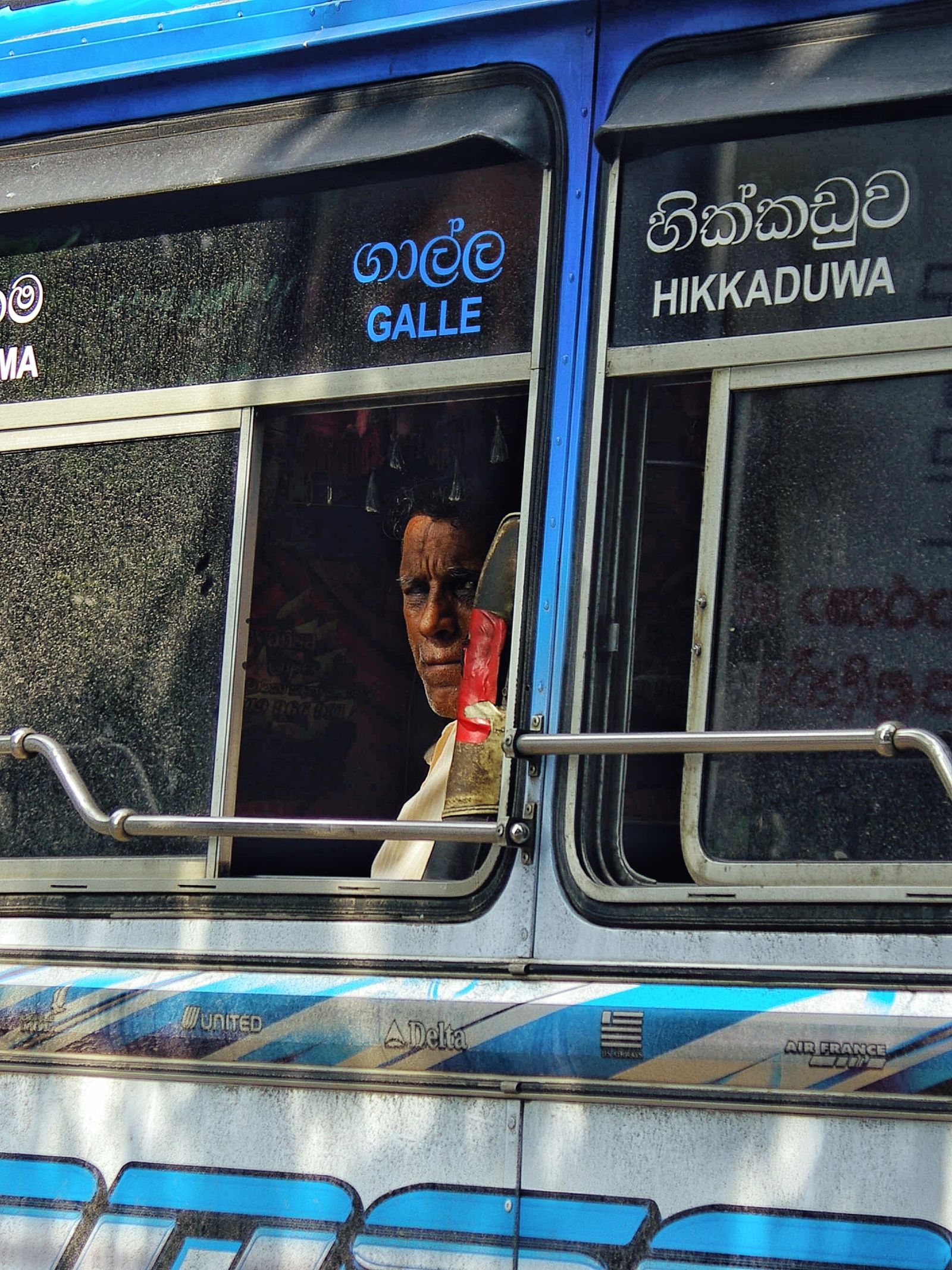 A passenger looking through a bus window in Sri Lanka