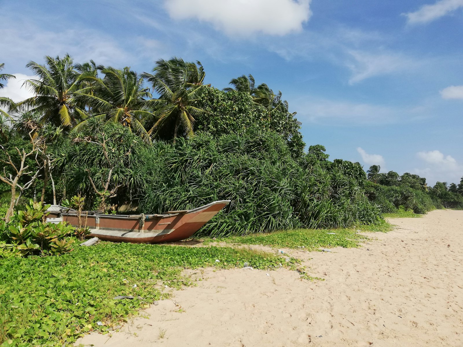a boat sitting on top of a sandy beach
